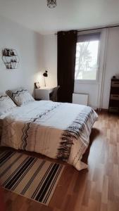 een slaapkamer met een bed en een raam bij Spacieux 4 chambres au cœur de Cergy in Cergy