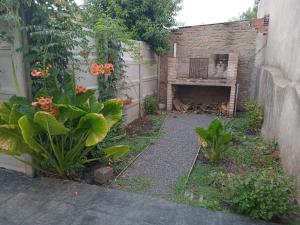 un patio trasero con una chimenea de ladrillo y plantas en La Paz en Lobos