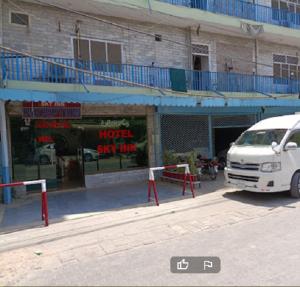 a white van parked in front of a building at Hotel Sky Inn in Rawalpindi