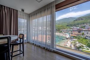 a room with a large window with a view of a beach at Blanche Cliff Apartments in Sveti Stefan