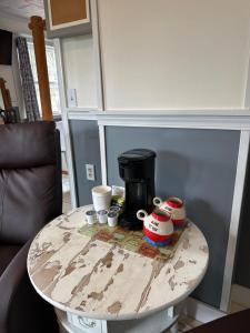 a coffee table with cups and a coffee maker on it at Foster Lake Inn in Sweet Home