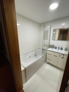 uma casa de banho branca com uma banheira e um lavatório em Costa Avila 2 em Caniço