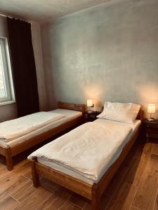 duas camas num quarto com duas lâmpadas nas mesas em Kerkira pub&restaurant em Veľké Úľany
