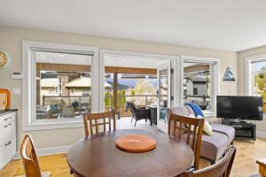 a living room with a table and chairs and a television at A Peaceful Suite Stay in Brentwood Bay