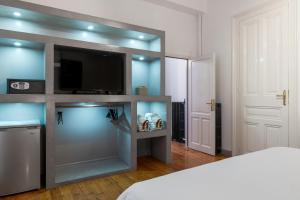 a bedroom with a flat screen tv and a bed at 2 Mazi Suites in Athens
