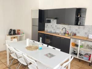 a kitchen with a white table and white chairs at Maison Individuelle Cozy Asterix, CDG, Paris, Disney, Olympic Games 2024 in La Chapelle-en-Serval