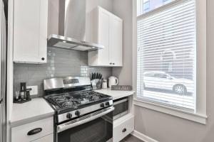 una cucina con piano cottura forno superiore accanto a una finestra di **NEW mOdernLUX best OTR condo *Park ONsite** a Cincinnati
