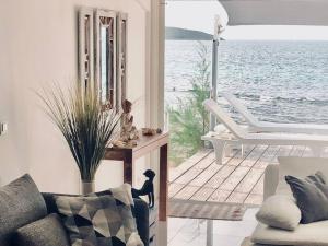 sala de estar con sofá y vistas al agua en DREAM ON THE BEACH, en Baie Nettle