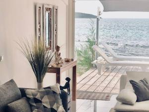 ein Wohnzimmer mit einem Sofa und Blick auf das Wasser in der Unterkunft DREAM ON THE BEACH in Baie Nettle