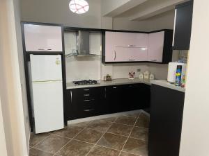 a kitchen with a white refrigerator and black cabinets at Villa Mimoza in Golem