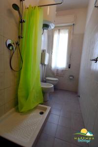 baño con ducha con cortina verde en Maremma Holidays : Trasimeno Apartment, en Follonica