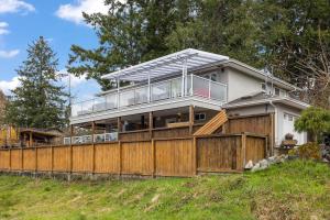 a house on a hill with a wooden fence at A Peaceful Suite Stay in Brentwood Bay