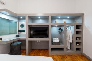 a bedroom with a tv and a large mirror at 2 Mazi Suites in Athens