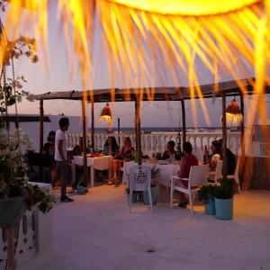 un groupe de personnes assises à des tables sur la plage dans l'établissement Dar Evelyne, à Mahdia