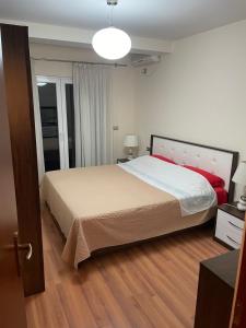 een slaapkamer met een groot bed en een houten vloer bij Villa Mimoza in Golem