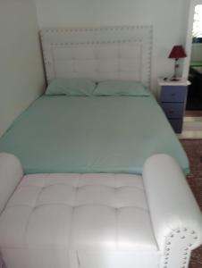 a white bed in a bedroom with a white headboard at Monoambiente Full Equipado - La Bussola in Las Heras