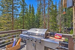 a grill on a deck with trees in the background at Nomad Haus with Mtn Views and Deck - 25 Mi to Breck! in Fairplay