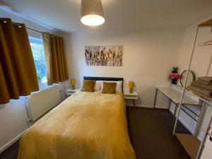 a bedroom with a bed with a yellow blanket at One Bed Apartment Stevenage in Stevenage