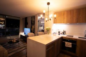 a kitchen with a kitchen island and a living room at Luxury apartment 37th floor en distrito de lujo in Santiago