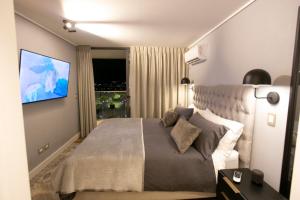 a bedroom with a large bed and a flat screen tv at Luxury apartment 37th floor en distrito de lujo in Santiago