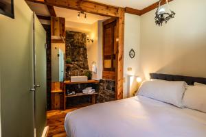 a bedroom with a bed and a stone wall at Gervasoni Hotel Boutique in Valparaíso