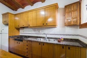 una cocina con armarios de madera y fregadero en Casas Rurales Los Enebros Nerpio, en Nerpio