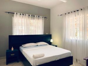 a bedroom with a bed with white sheets and a window at Bharazah Luxury Apartment in Malindi