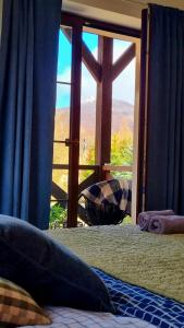 a bedroom with a bed and a window with a view at Pokoje Gościnne Słotwińscy in Wetlina