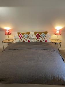 イブシャムにあるLittle Moat - Moat Farm Barns a small modern studio in the garden on our family farmのベッドルーム1室(大型ベッド1台、ランプ2つ付)