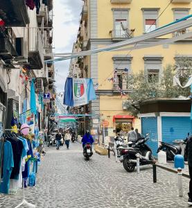 une personne circulant en moto dans une rue avec des bâtiments dans l'établissement 'A Room de' Scugnizzi, à Naples