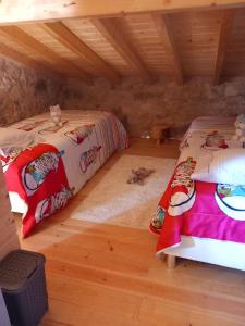 2 letti in una camera con pavimento in legno di Carregã Water mill a Penela
