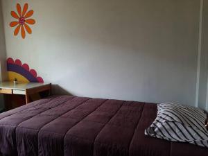 een slaapkamer met een paars bed en een bureau bij Cabañas SHOLLET in Oxapampa