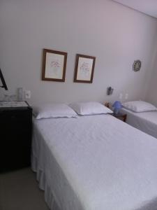穆库热Recanto de Flor的一间卧室，墙上有两张床和两幅画