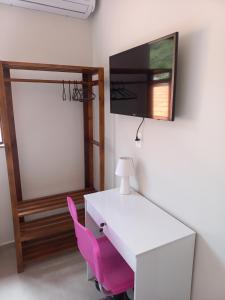 a white desk and a pink chair in a room at Recanto de Flor in Mucugê