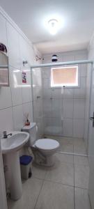 a white bathroom with a toilet and a sink at Ap23 Cristal do Indaiá I 450m praia in Bertioga +46 photos
