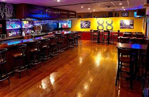a bar with wooden floors and bar stools in a room at Bicentennial Inn in Buckhannon