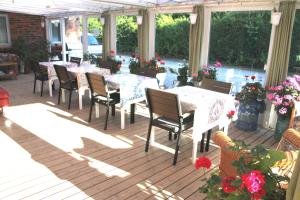 a patio with tables and chairs and flowers at Hine Bakke Bed And Breakfast in Rudkøbing