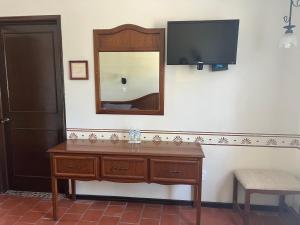a dresser with a mirror and a television on a wall at Hotel Real de Huasca in Huasca de Ocampo