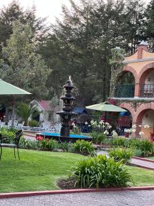 una fuente en un parque frente a un edificio en Hotel Real de Huasca, en Huasca de Ocampo