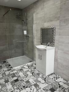 een badkamer met een douche, een wastafel en een spiegel bij Blue Cottage in Valentia Island