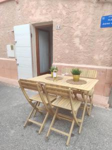 einen Holztisch mit zwei Stühlen neben einem Gebäude in der Unterkunft Chill Out Cabanon Coeur Calanques in Marseille
