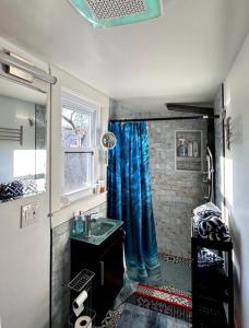 a bathroom with a sink and a blue shower curtain at Unique Artsy 2 Bdrm Apt 1.5 mi from Downtown in Pittsburgh