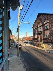 une rue urbaine vide avec une voiture garée dans la rue dans l'établissement Unique Artsy 2 Bdrm Apt 1.5 mi from Downtown, à Pittsburgh