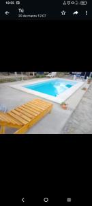 una imagen de una piscina con cama de madera en La Rosadita en Termas de Río Hondo