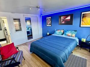 a blue bedroom with a bed and a chair at Unique Artsy 2 Bdrm Apt 1.5 mi from Downtown in Pittsburgh