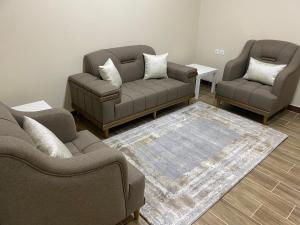 a living room with two couches and a rug at شقق مساكن الاميره in Yanbu