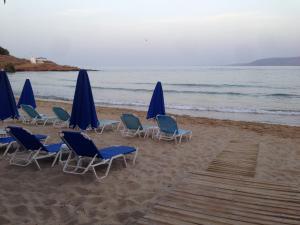 a group of chairs and umbrellas on a beach at KALIVAKI in Georgioupolis +4 photos
