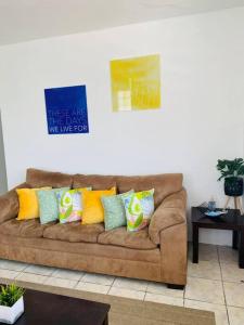 una sala de estar con un sofá marrón con almohadas coloridas en 3BR spacious, dorado beach apartment, -20% monthly, en Dorado