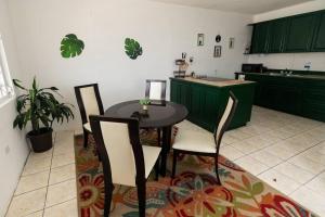 uma cozinha com armários verdes e uma mesa e cadeiras em 3BR spacious, dorado beach apartment, -20% monthly em Dorado