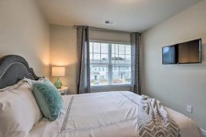 a bedroom with a bed and a tv and a window at Modern 3BR Townhome 10 mins to Downtown ATL in Atlanta +8 photos